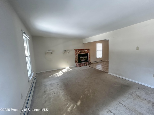203 Willow Rd, Dalton, PA 18414 - unfurnished living room featuring baseboard heating, a brick fireplace, and baseboards