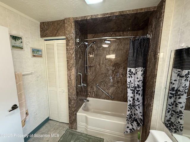 full bath featuring shower / bath combination with curtain, a textured ceiling, tile walls, and a closet