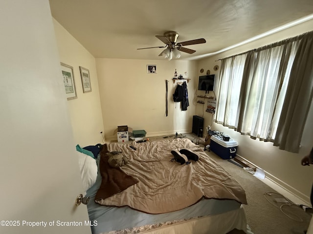 carpeted bedroom with baseboards and a ceiling fan