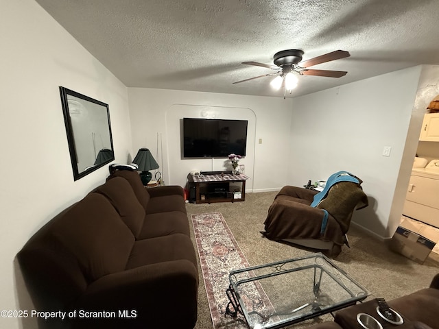 carpeted living room featuring washer / dryer, ceiling fan, baseboards, and a textured ceiling