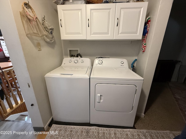 clothes washing area featuring cabinet space, baseboards, and washer and dryer