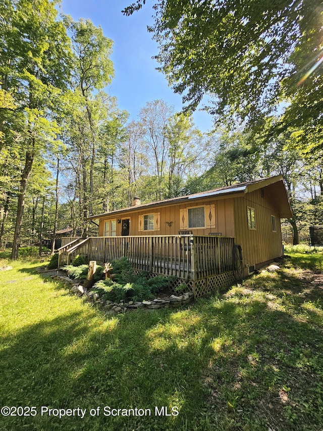 55 Lyman Ln, Gouldsboro, PA 18424 - view of front of home with a front lawn, a chimney, a wooden deck, and board and batten siding