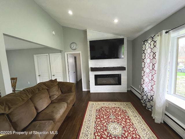 living room with lofted ceiling, a large fireplace, a baseboard radiator, dark wood finished floors, and plenty of natural light