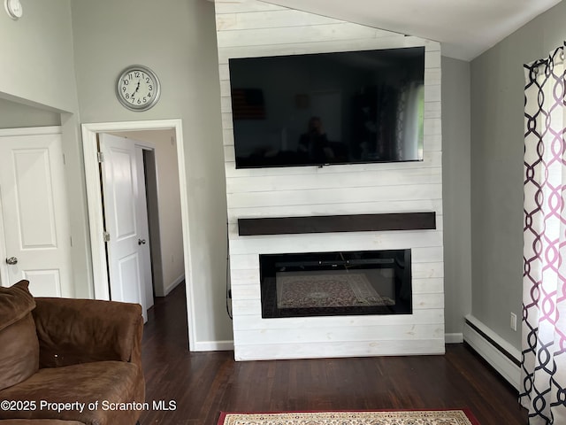living area featuring baseboard heating, dark wood finished floors, a fireplace, and baseboards