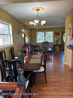 dining space featuring a notable chandelier and wood finished floors