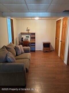 living room featuring a drop ceiling and wood finished floors