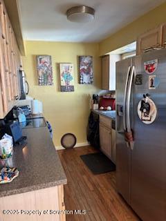 kitchen featuring stainless steel fridge, light wood-style flooring, and baseboards