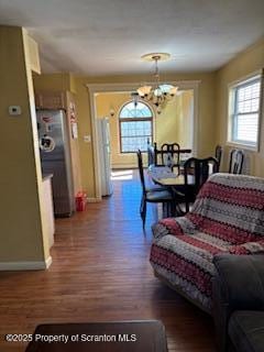 dining space featuring a notable chandelier, baseboards, and wood finished floors