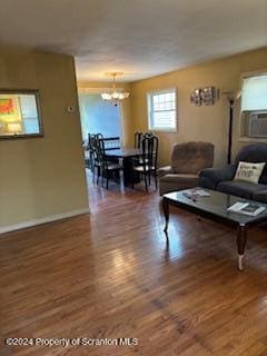 living room with dark wood-type flooring and a notable chandelier