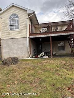 back of house with a wooden deck and a yard