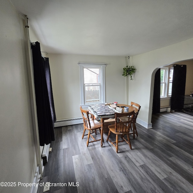 612 Ferdinand St, Scranton, PA 18508 - dining room featuring arched walkways, plenty of natural light, a baseboard heating unit, and dark wood finished floors