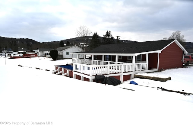 snow covered house featuring covered porch