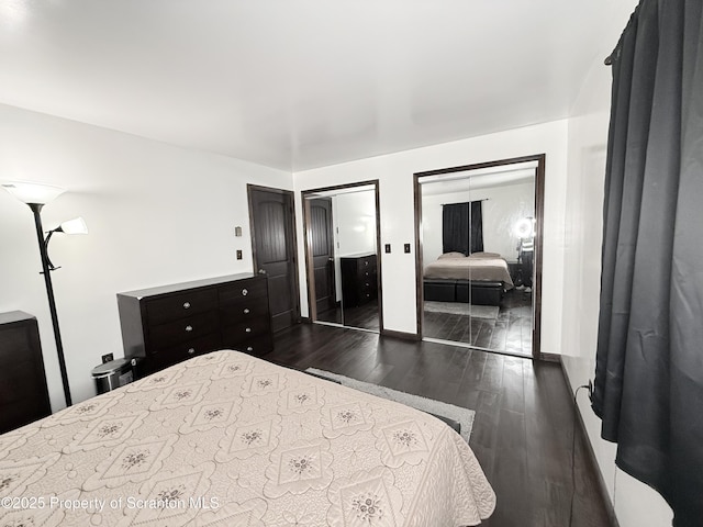 bedroom with multiple closets and dark hardwood / wood-style flooring