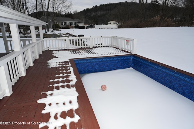 snow covered pool featuring a deck