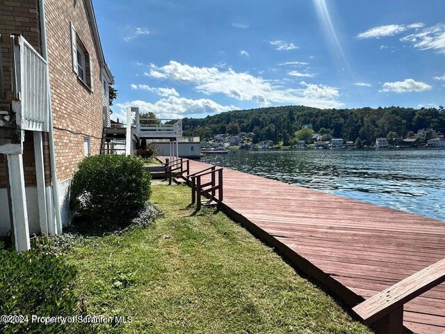 view of dock featuring a water view and a yard