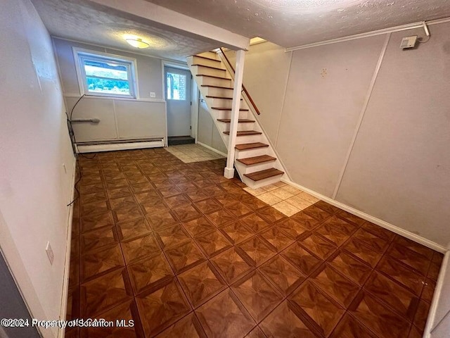 basement with a baseboard radiator and a textured ceiling