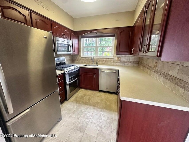 kitchen featuring decorative backsplash, sink, and appliances with stainless steel finishes