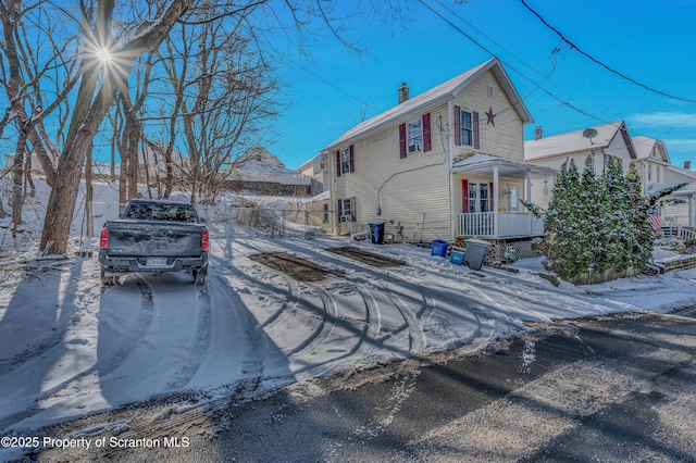 snow covered property featuring a porch