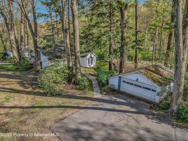 view of side of home with an outdoor structure, a garage, and a shed