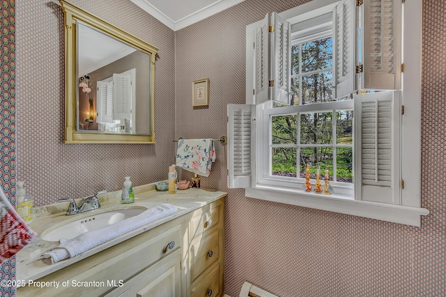 bathroom with wallpapered walls, vanity, and ornamental molding