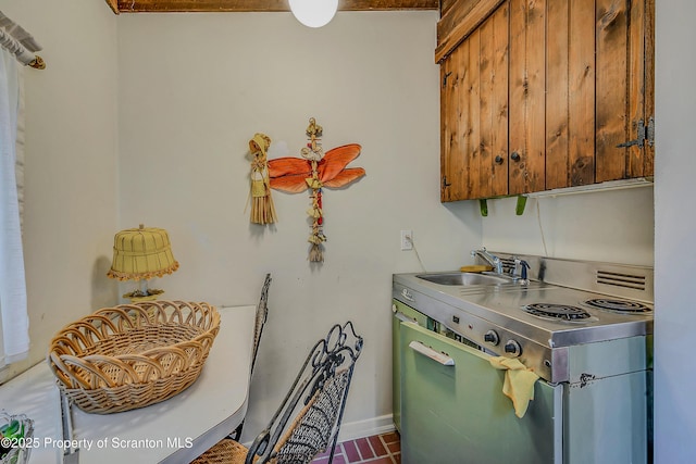 kitchen with stainless steel countertops, electric stove, baseboards, and a sink