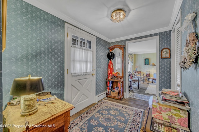 entrance foyer featuring wood finished floors, wallpapered walls, ornamental molding, and baseboard heating
