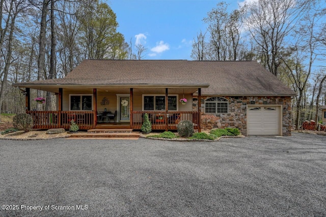 37 S Lehigh River Dr, Clifton Twp, PA 18424 - view of front of house featuring covered porch, an attached garage, a shingled roof, stone siding, and driveway