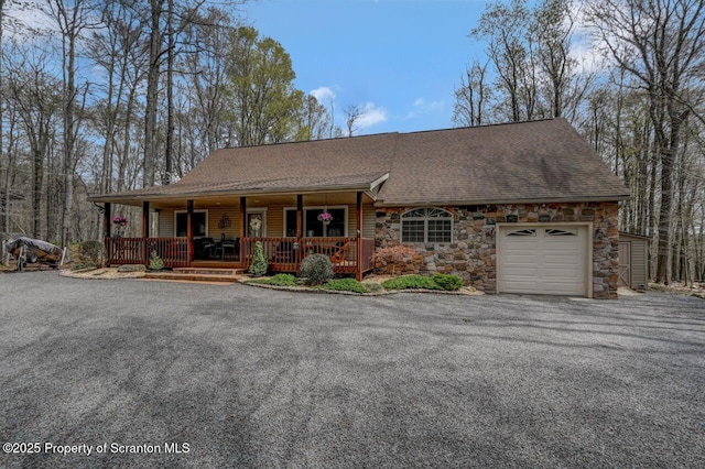 37 S Lehigh River Dr, Clifton Twp, PA 18424 - view of front of property featuring covered porch, a shingled roof, stone siding, a garage, and driveway