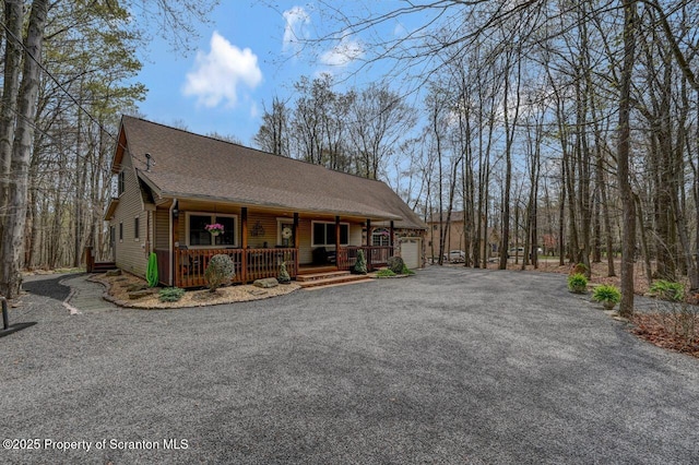 37 S Lehigh River Dr, Clifton Twp, PA 18424 - chalet / cabin with covered porch, asphalt driveway, an attached garage, and a shingled roof