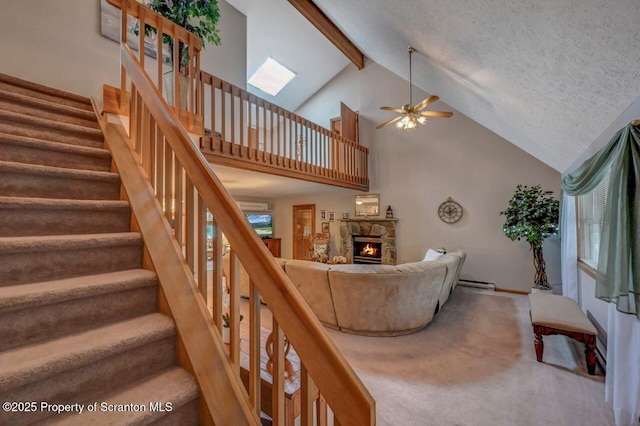 37 S Lehigh River Dr, Clifton Twp, PA 18424 - carpeted living area with ceiling fan, a stone fireplace, a baseboard heating unit, high vaulted ceiling, and stairs