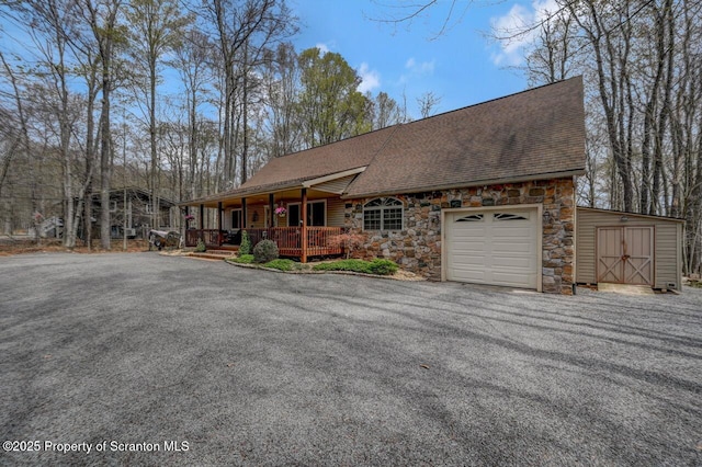 37 S Lehigh River Dr, Clifton Twp, PA 18424 - view of front facade with stone siding, a porch, a shingled roof, an attached garage, and asphalt driveway