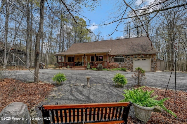 37 S Lehigh River Dr, Clifton Twp, PA 18424 - view of front facade with a porch, asphalt driveway, a garage, and stone siding