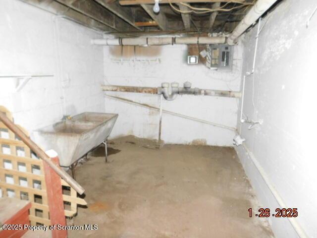 basement with electric panel and sink