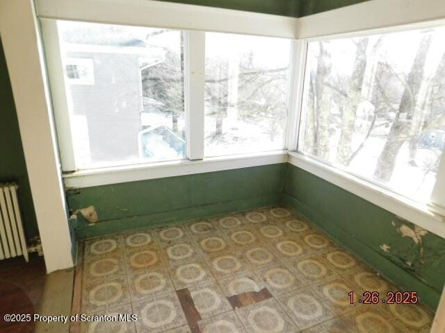 sunroom / solarium featuring radiator heating unit