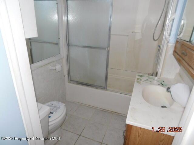 full bathroom with enclosed tub / shower combo, vanity, toilet, and tile patterned floors