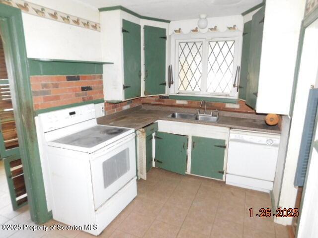 kitchen with sink, light tile patterned floors, and white appliances