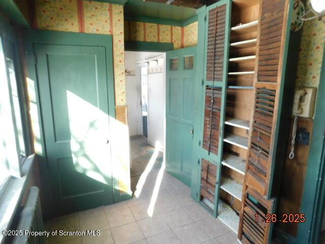 interior space with radiator and light tile patterned floors