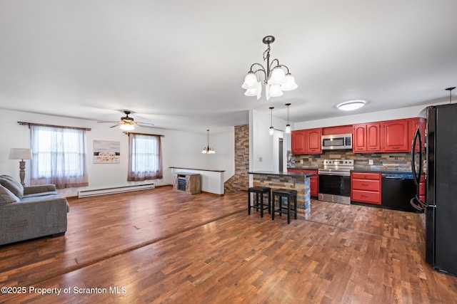609 Landmesser Ave, West Hazleton, PA 18202 - kitchen featuring stainless steel appliances, baseboard heating, a chandelier, open floor plan, and dark countertops