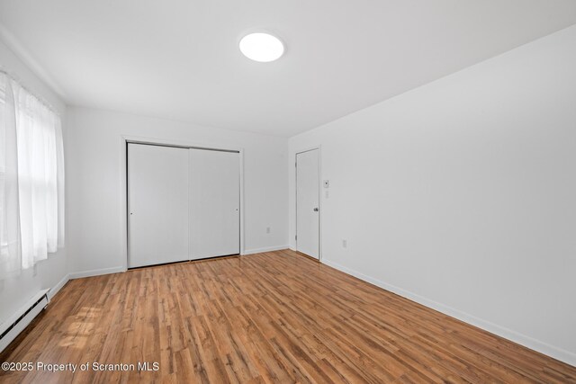 609 Landmesser Ave, West Hazleton, PA 18202 - unfurnished bedroom with baseboard heating, wood finished floors, and a closet