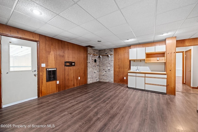 609 Landmesser Ave, West Hazleton, PA 18202 - unfurnished living room with dark wood-style floors, wooden walls, a paneled ceiling, and heating unit