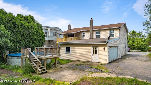 609 Landmesser Ave, West Hazleton, PA 18202 - back of house featuring a deck, a chimney, an attached garage, stairway, and driveway
