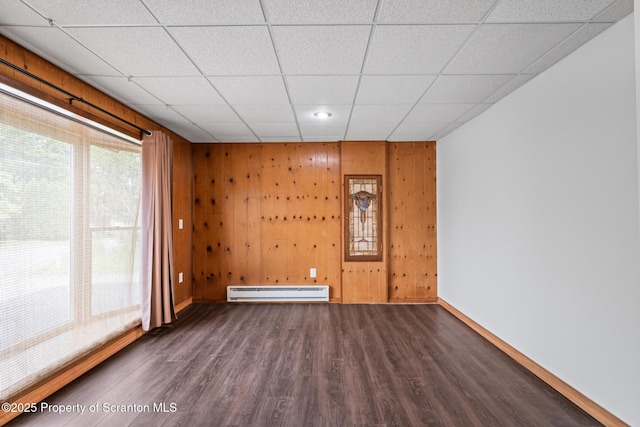 609 Landmesser Ave, West Hazleton, PA 18202 - unfurnished room with a baseboard radiator, a drop ceiling, wood finished floors, and wooden walls