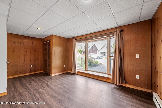 609 Landmesser Ave, West Hazleton, PA 18202 - unfurnished room with a baseboard heating unit, dark wood-style flooring, wood walls, and a paneled ceiling