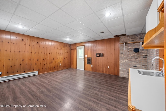 609 Landmesser Ave, West Hazleton, PA 18202 - unfurnished living room featuring a baseboard heating unit, wood finished floors, and wood walls