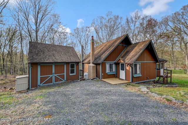 3222 Bluebird Dr, Bushkill, PA 18324 - chalet / cabin with a shingled roof, an outdoor structure, a chimney, and a shed