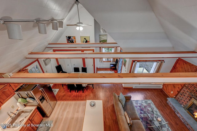 3222 Bluebird Dr, Bushkill, PA 18324 - stairway featuring high vaulted ceiling, ceiling fan, a skylight, and wood finished floors