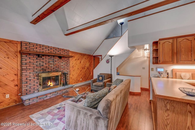 3222 Bluebird Dr, Bushkill, PA 18324 - living room with wood walls, a fireplace, beam ceiling, and wood finished floors