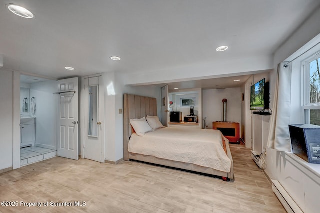 3222 Bluebird Dr, Bushkill, PA 18324 - bedroom featuring light wood-type flooring, baseboards, a baseboard heating unit, a wood stove, and recessed lighting