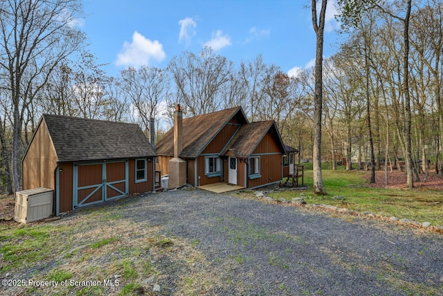 3222 Bluebird Dr, Bushkill, PA 18324 - view of front facade with a chimney, an outbuilding, and a storage unit