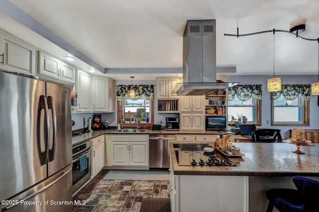 kitchen featuring sink, appliances with stainless steel finishes, island range hood, and decorative light fixtures